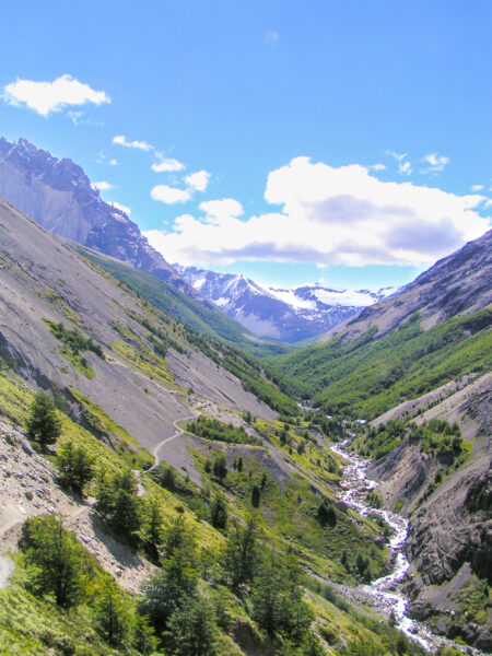 Ein schmaler Fluss windet sich durch ein Tal in Patagonien. Das Foto wurde von einem Wanderweg am Weg zu den Torres del Paine im Zuge einer Wanderreise mit Weltweitwandern aufgenommen.