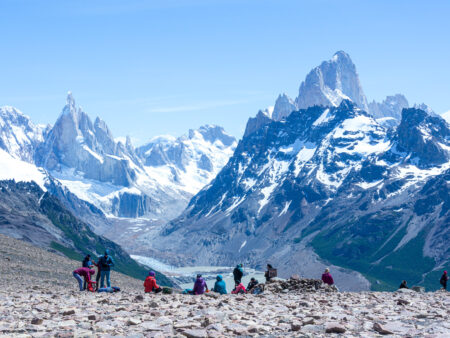 Eine Gruppe Wanderreisender mit Weltweitwandern sitzt auf einem Abhang und schaut hinüber auf den Loma del Pliegue Tumbado in Patagonien.