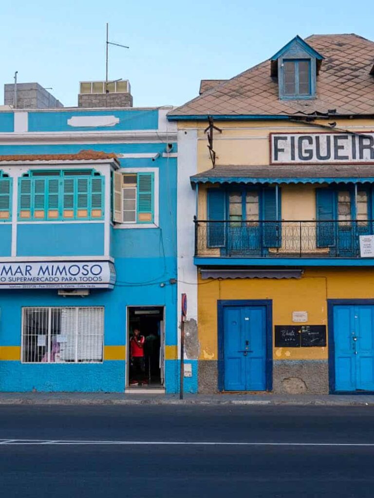Wir sehen zwei Gebäude entlang einer Straße in Mindelo auf der Insel Insel São Vicente in Kap Verde.