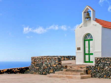 Ein Bild der Ermita de Guará auf der Insel La Gomera in den Kanaren. Im Hintergrund kann man den strahlend blauen Himmel und auch den atlantischen Ozean erkennen.