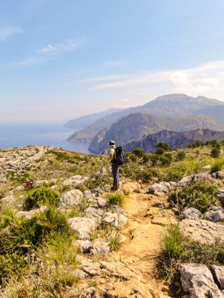 Eine Person auf Wanderreise steht vor einer atemberaubenden Aussicht an der Nordwestküste von Mallorca.