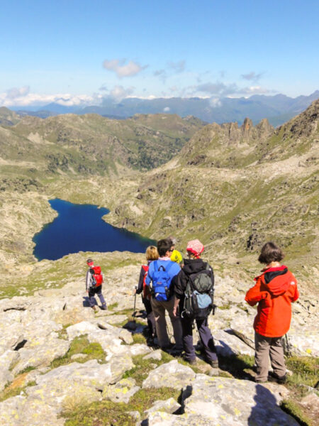 Eine kleine Gruppe auf Wanderreise schaut hinunter auf einen der eiszeitlichen Bergseen im 