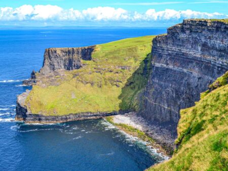 Man sieht steile Klippen der Cliffs of Moher in Irland.