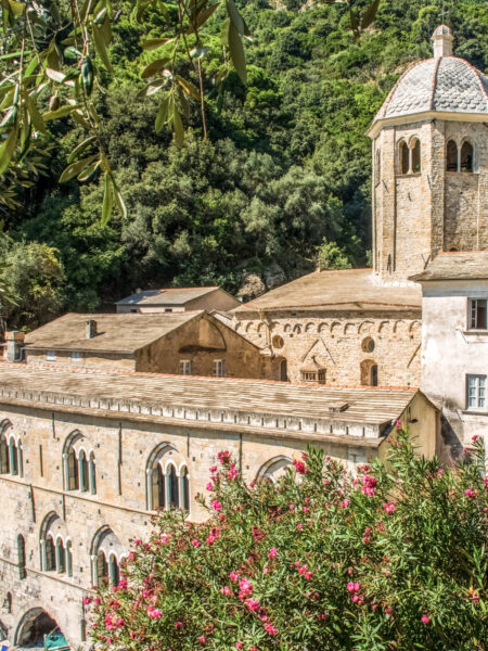 Das Bild zeigt die Abtei San Fruttuoso in Ligurien in Italien vor einem Wald-Hintergrund.