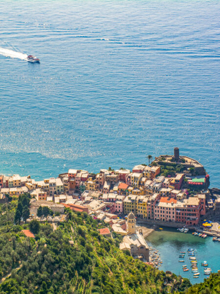 Die Ortschaft Vernazza von oben fotografiert. Im Meer vor der Hafen der Ortschaft, die zu den Cinque Terre gehört, sieht man ein Boot.