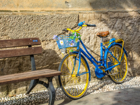 Ein blaugelbes Fahrad lehnt an einer Wand in der Altstadt von Monterosso in Ligurien.
