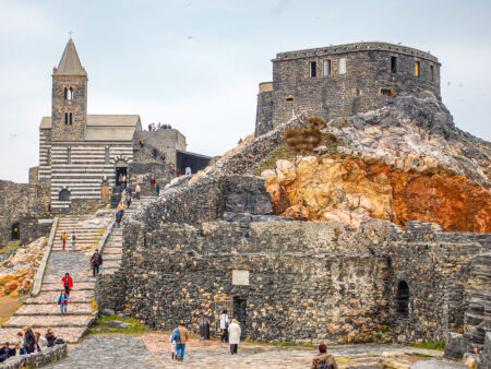 Links im Bild ist die Kirche San Pietro in Portovenere zu erkennen, während man rechts die Festung der Stadt sehen kann. Beide können auf einer Reise mit Weltweitwandern gesehen werden.
