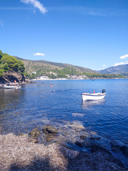 Ein Bucht im Cilento in Italien, auf dem strahlend blauen Wasser treibt ein kleines Ruderboot.