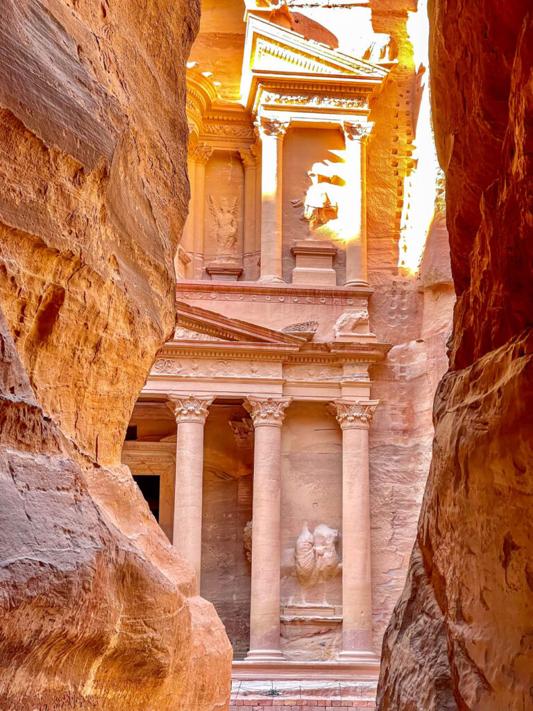 Man sieht einen kleinen Ausschnitt der Felsenstadt Petra aus dem Siq heraus. Dieser Anblick ist der erste, der auf einer Wanderung bis zur Felsenstadt gewähnlich offenbart wird.