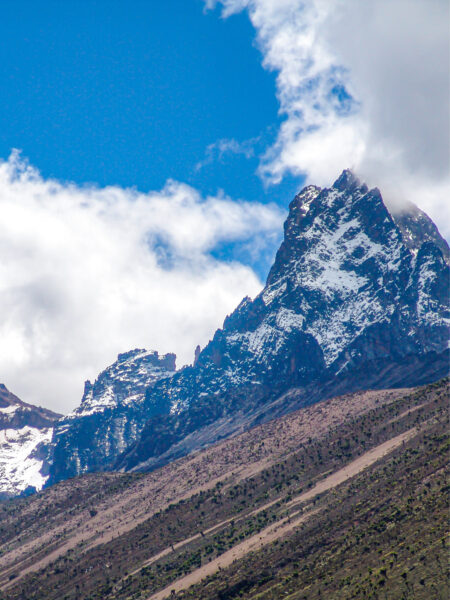 Im Foto ragt der Mount Kenya hoch in den Himmel auf. Der Berg ist der zweithöchste Gipfel in Afrika und Teil einer Reise mit Weltweitwandern.