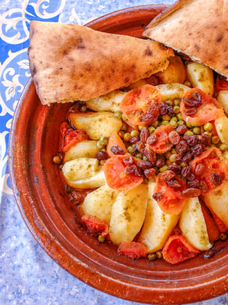 Eine marokkanische Tajine mit Fladenbrot. Das traditionelle Gericht wird einem kegelförmigen Topf zubereitet.