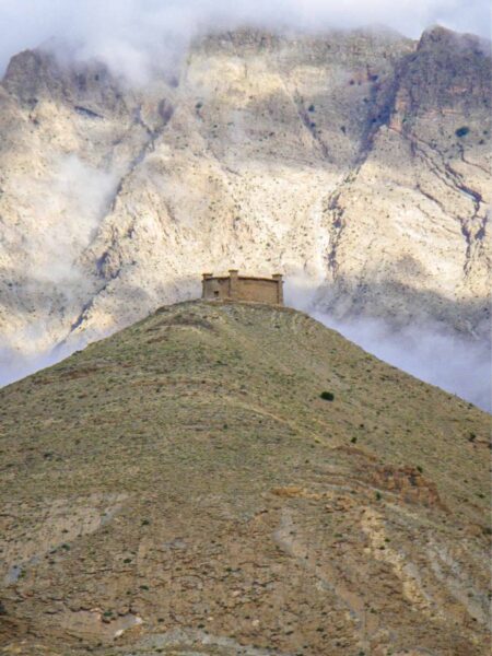 Auf dem Bild können wir ein besfestigtes Dorf im Hohen Atlas erkennen, das auf dem Gipfel eines niedrigen Bergs oder Hügels thront.
