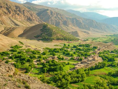 Ein grünes Tal im Hohen Atlas in Marokko, im Hintergrund Berge, die man im Zuge einer Wanderreise besteigt.