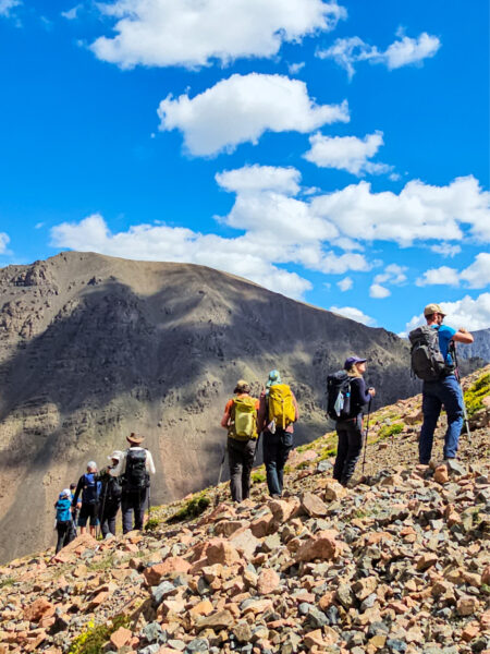 Eine kleine Gruppe auf einer Trekkingreise durch den Westen der Mongolei folgt ihrem Guide über einen Gebirgszug.