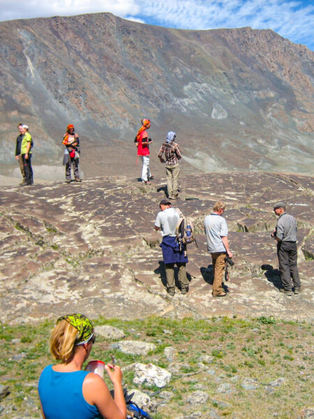 Eine kleine Gruppe auf Wanderreise steht vor einer Aussicht in der Gebirgslandschaft der Mongolei.