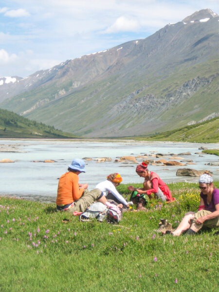 Mehrere Personen auf Wanderreise machen am Bild gerade eine Pause am Ufer eines Sees im Westen der Mongolei. Dabei handelt es sich womöglich um den Khoto-See.
