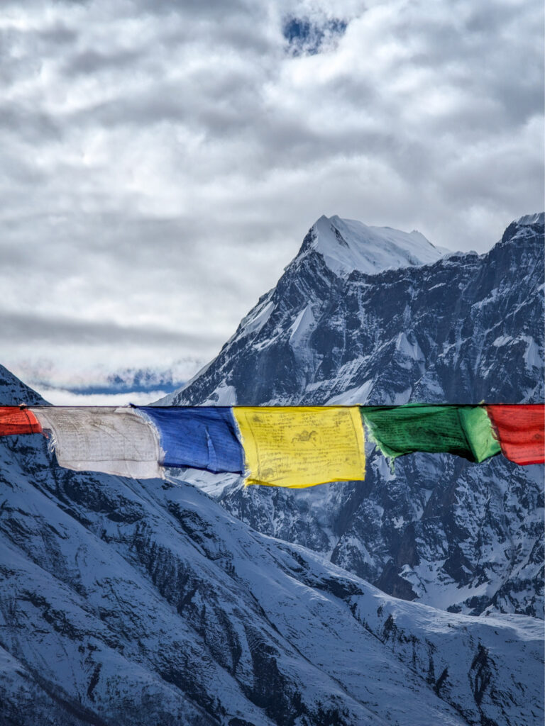 Mehr Gebetsfahnen hängen vor dem Hintergrund des Annapurnamassivs in Nepal.