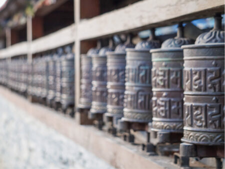 Eine Reihe von buddhistischen Gebetsmühlen in Nepal ist auf dem Bild zu sehen. Das Foto wurde in einem Tempel entlang des Annapurna-Circuit aufgenommen.