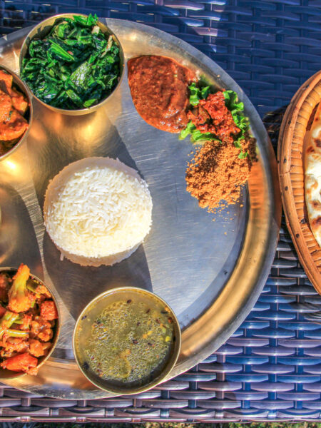 Ein nepalesisches Gericht, bestehend aus Gemüse, Reis und Saucen, das den Teilnehmenden einer Reise von Weltweitwandern serviert wurde.