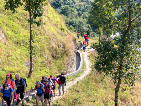 Mehrere Wander*innen gehen einen Weg in Nepal entlang.