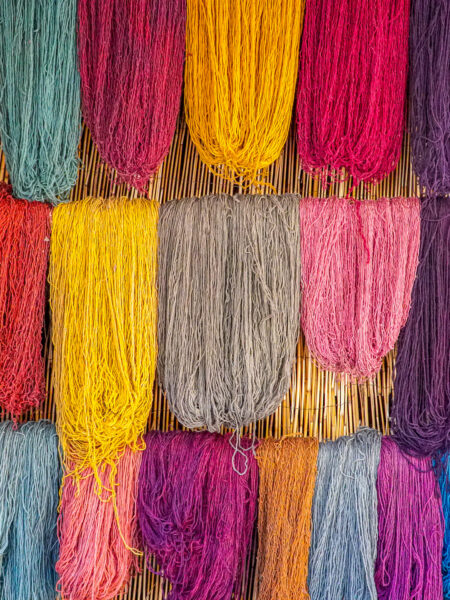 Man sieht buntes Garn, oder bunte Wolle, die aufgehängt wurde im heiligen Tal der Inka.