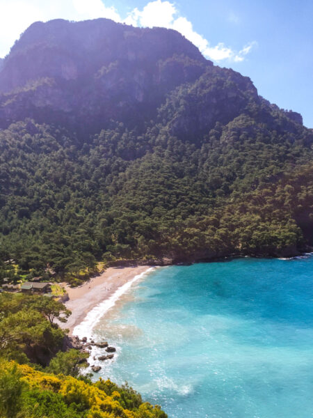 Das Bild zeigt einen Sandstrand in der Türkei von einer Anhöhe aus. Es handelt sich dabei um die Kabak-Bucht und das Foto wurde von einem Wanderweg aus aufgenommen.