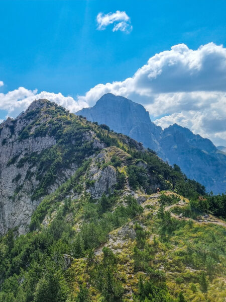 Man sieht den Valbona-Pass, einen schmalen Wanderweg, über das Bergland des Balkans.