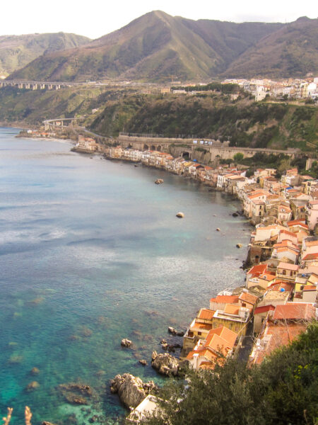 Eine kleine Küstenstadt auf Sizilien oder in Kalabrien. Die Häuser der Ortschaft schmiegen sich direkt an die Bucht.