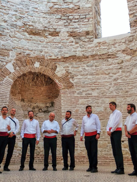 Eine Gruppe Einheimischer stehen in den Ruinen eines alten römischen Palasts in der UNESCO-Weltkulturerbe-Altsadt von Split in Kroatien.