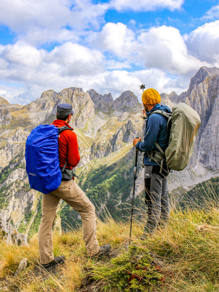 Ein Guide und Wanderer auf einem Balkan-Trip stehen an einem Aussichtspunkt und überblicken das Bergland am Balkan.