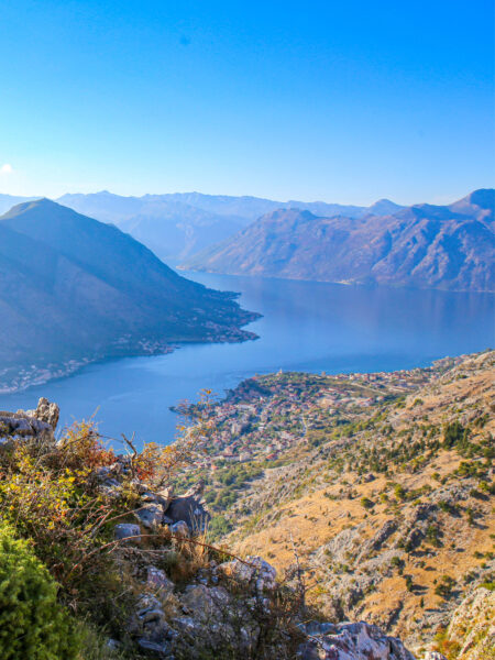 Auf dem Bild sieht man einen Teil der Buch von Kotor in Montengro. Das strahlend blaue Wasser leuchtet zwischen den Berggipfel rund um den See hervor.