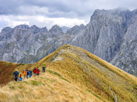 Ein Guide von Weltweitwandern führt eine kleine Reisegruppe über den Grat eines Berges in den albanischen Alpen, oder Prokletje.