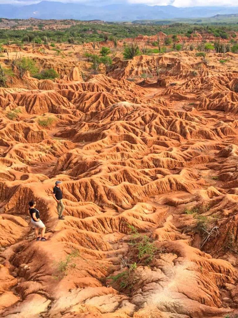 Zwei Personen stehen auf dem felsigen Untergrund der Taracoa Wüste in Kolumbien. Sie sind Teil einer Reise mit Weltweitwandern.