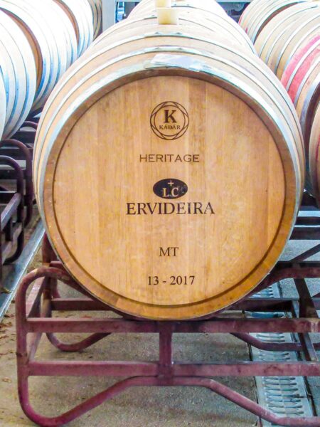 Ein Weinfass steht in einem Weingut in Alentejo. Man sieht es von vorne und kann den Schriftzug auf dem Fass lesen: Ervideira.