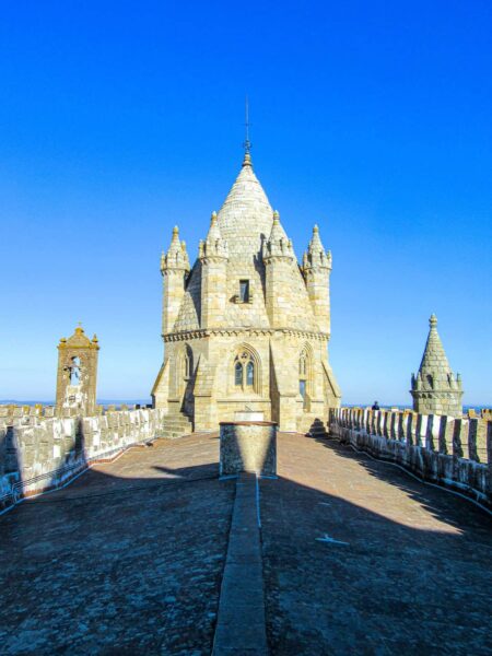 Die Kathedrale von Évora in Portugal ist von vorne erkennbar. Sie ist von der Sonne beschienen und die Steine des alten Gebäudes in Portugal sind scheinbar mit Salz verkrustet.