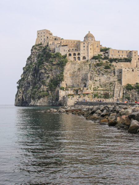 Das Bild zeigt eine nähere Aufnahme des Castello Aragonese vor der Küste von Ischia.