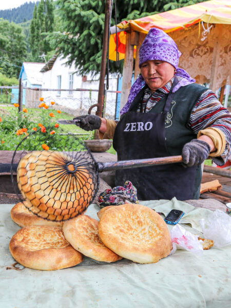 Eine Frau backt traditionelles, zentral-asiatisches Brot.