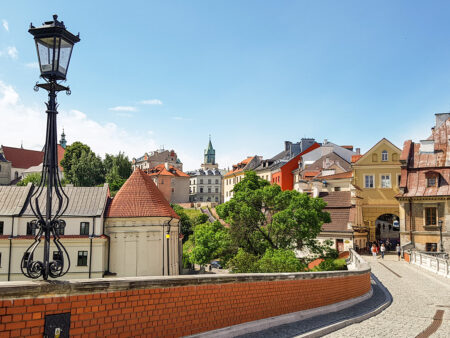 Man sieht einen Teil der Altstadt von Lublin in Polen. Eine Laterne sowie ein erhöhter Pfad beziehungsweise eine Brücke sind auf dem Bild erkennbar.