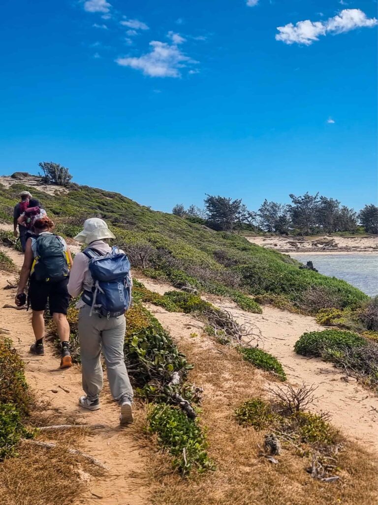 Eine kleine Gruppe Wanderreisender geht an der Küste im Norden von Madagaskar entlang.