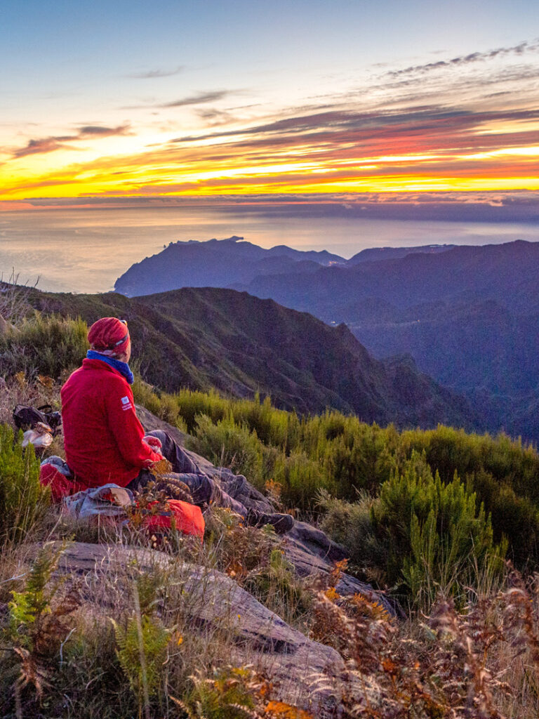 Eine Person auf Wanderreise genießt den Ausblick auf den Sonnenauf- oder -untergang auf Madeira.