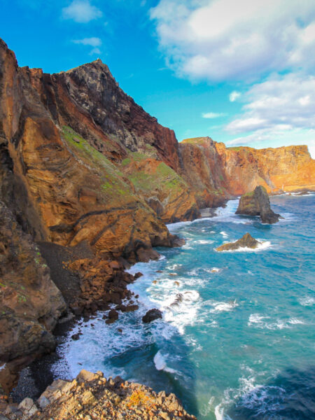 Man sieht die schroffen Klippen von Madeira über dem Atlantik aufragen.