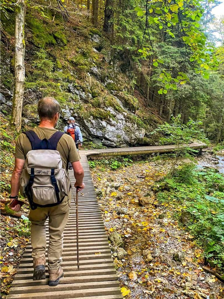 Zwei Personen auf Wanderreise mit Weltweitwandern gehen einen ausgebauten Weg in der Klamm Diery in der Slowakei hinuntern.