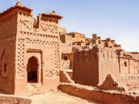 Wir sehen einen Teil des das historische, befestigte Dorf Aït-Ben-Haddou in Marokko. Die UNESCO-Weltkulturerbe-Stätte ist gekennzeichnet durch den rötlichen Sandstein, aus dem die ganze Gebäude errichtet wurden.