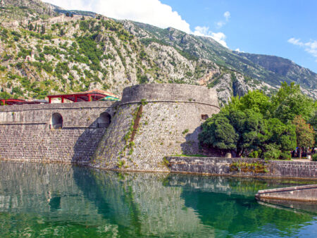 Ein Teil der Stadtmauern von Kotor in Montenegro. Die Mauern liegen zu Teilen im Wasser, um auch historisch gesehen auch vor Angriffen mit Schiffen schützen zu können.