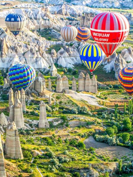 Man sieht bunte Heißluftballone über der Region Kappadokien in der Türkei aufsteigen. Sie sind ein gelobtes Highlight auf der Wanderreise mit Weltweitwandern.