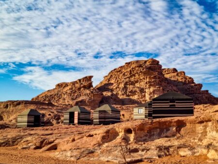 Das Beduinenzeltcamp, in dem Reisende mit Weltweitwandern übernachten, steht vor einer Felsformation in der Wadi Rum in Jordanien.
