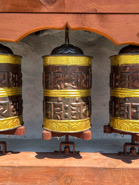 Auf dem Bild sieht man drei Gebetstrommeln in einer buddhistischen Tempel entlang des Annapurna- oder Manaslu-Trekks in Nepal.