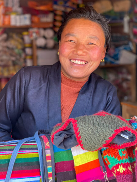 Eine nepalische Einheimische lächelt in die Kamera der Wanderreisenden.