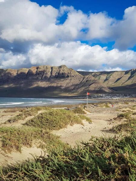 Wir sehen den den bekannten Strand von Famara auf Lanzarote. Er ist fünf Kilometer lang und bietet sich perfekt zum Wandern auf der spanischen Insel an.