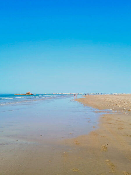 Ein Sandstrand in der Stadt Agadir im Südwesten von Marokko. Hier laden die Sonne und der blaue Himmel zum Baden nach langen Wandertagen in der Wüste ein.